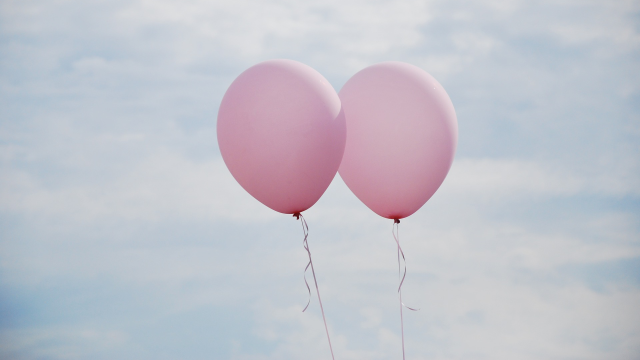 Two pink balloons in the air