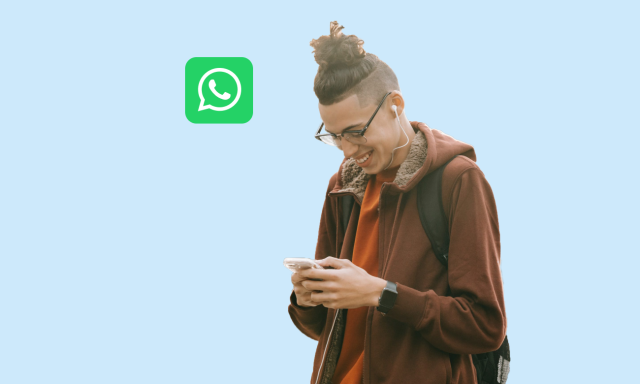 guy smiling with phone in hands and whatsapp logo